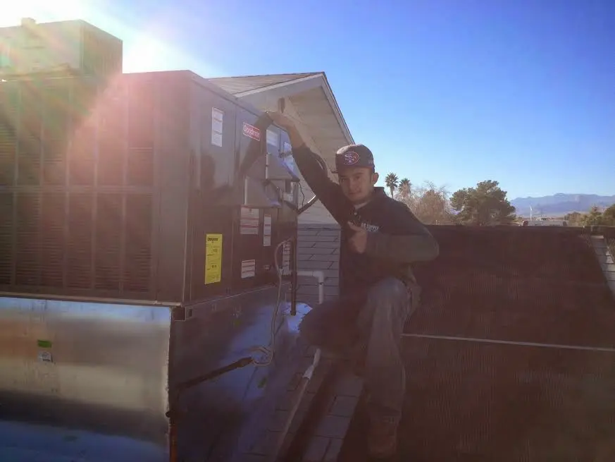 HVAC technician performing AC Tune-Up on a rooftop unit in Cave Creek